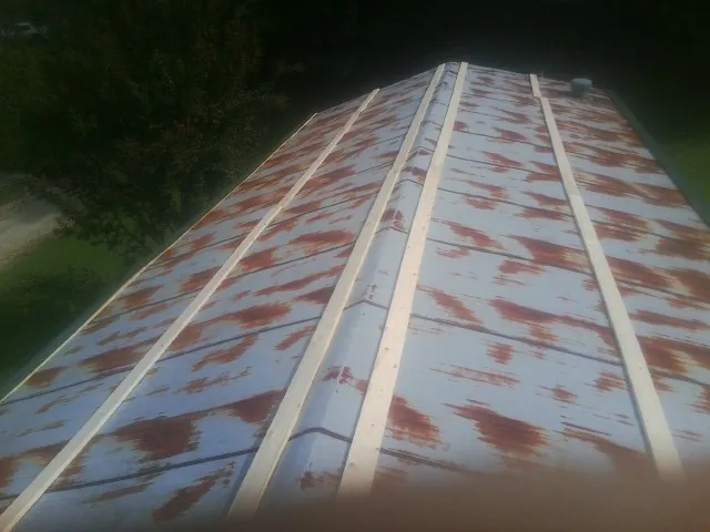 Rusted metal roof panels with new wood purlins before replacement — Storm Damage Roof Repair in Ravena by Roofing Brothers