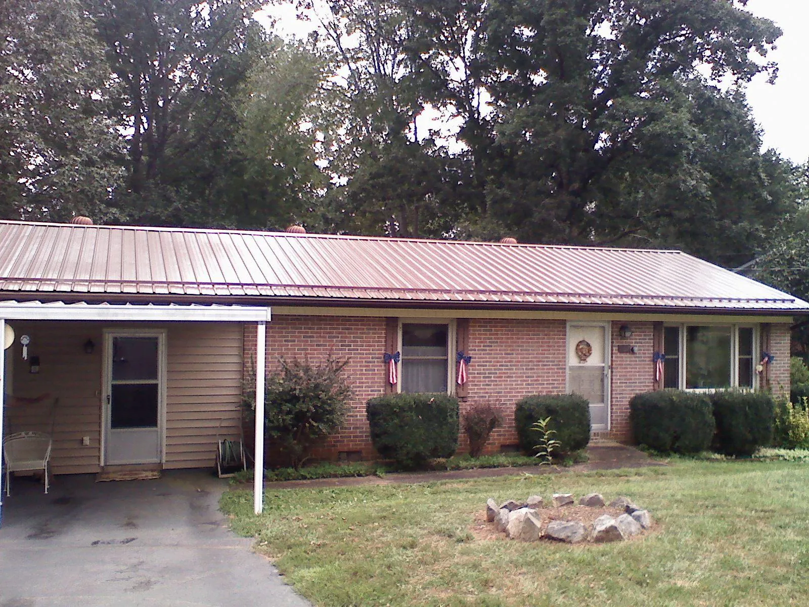 Bronze metal roof and carport on a brick ranch home — Roof Repair work by our crew in Ravena